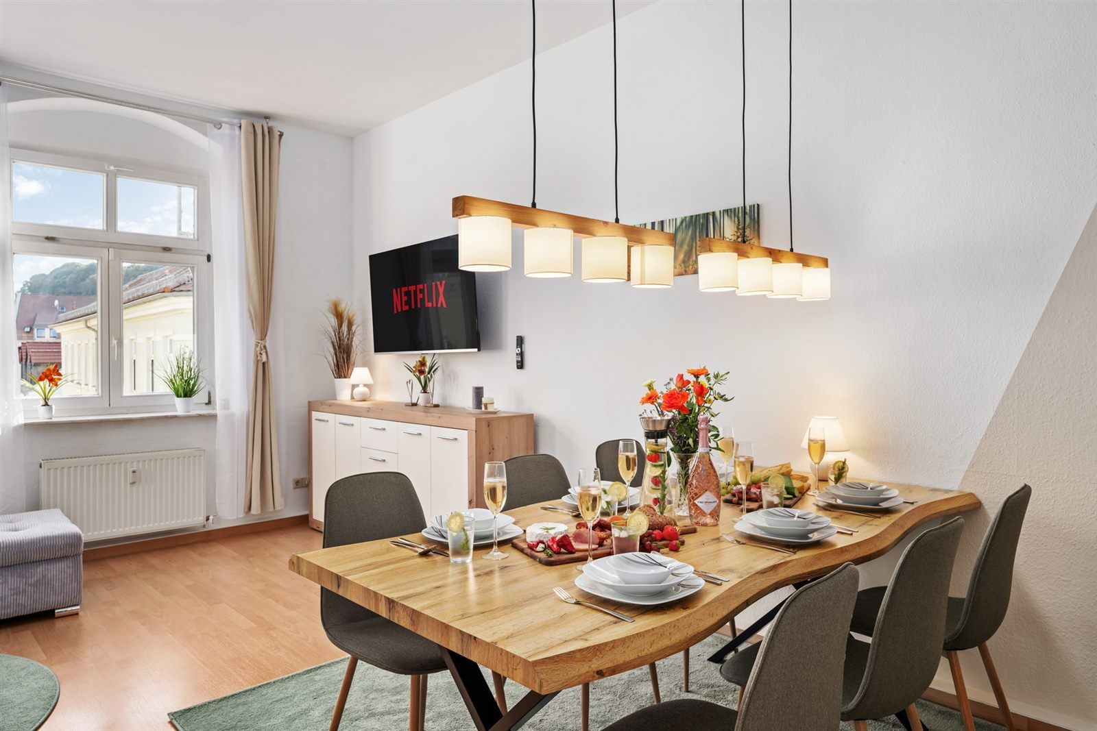 Einladendes Esszimmer mit großem Massivholztisch für sechs Personen und Smart-TV – gemeinsame Mahlzeiten und Filmabende