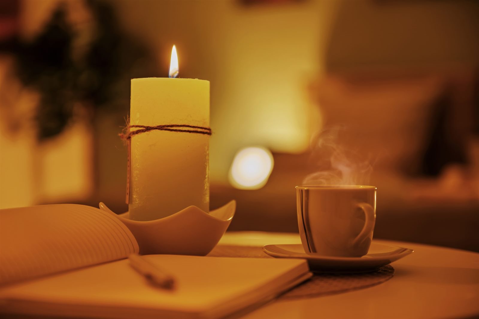 Dampfender Kaffee, Kerze und Notizbuch – kleine Auszeit für einen Moment ganz für sich