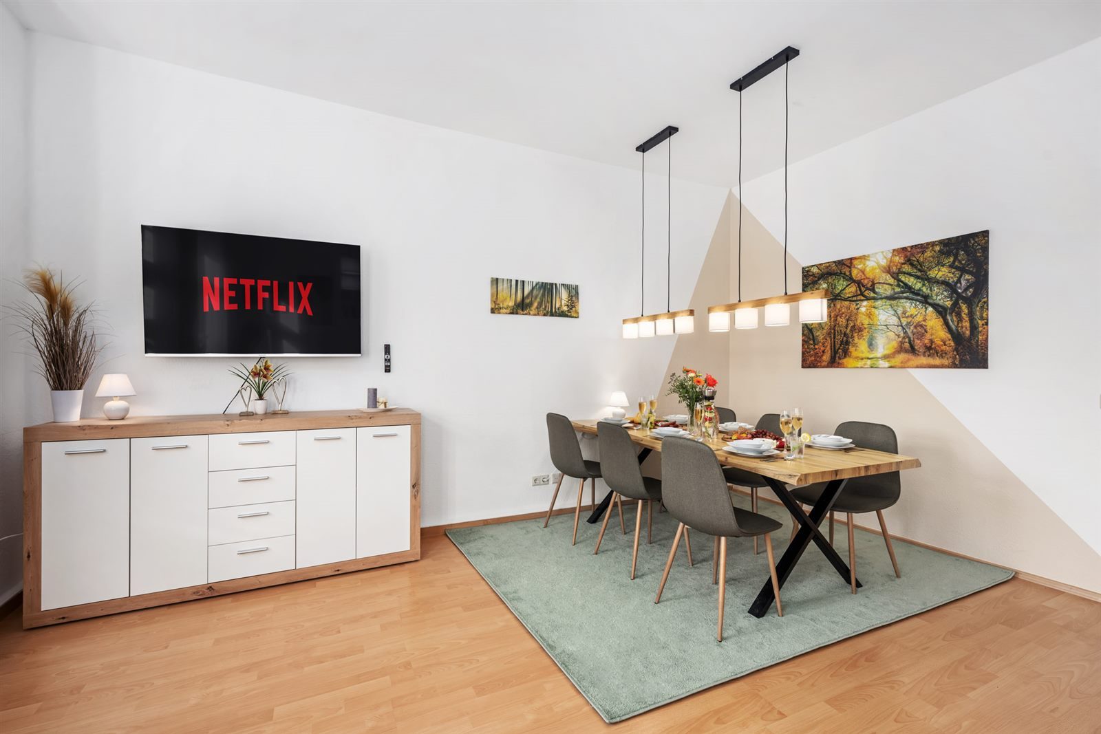 Großer Esstisch für sechs Gäste vor dem Smart-TV – gemeinsam essen, spielen und Filme genießen