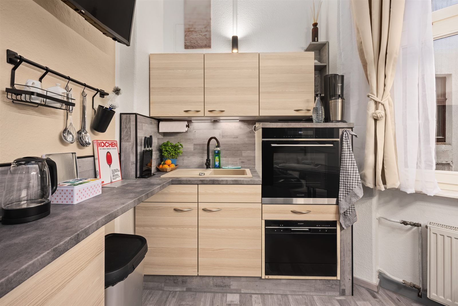 Voll ausgestattete Küche der SmartLuxusOase Meißen mit Induktionsherd, Backofen und komplettem Geschirr – kochen Sie so unbeschwert wie zu Hause
