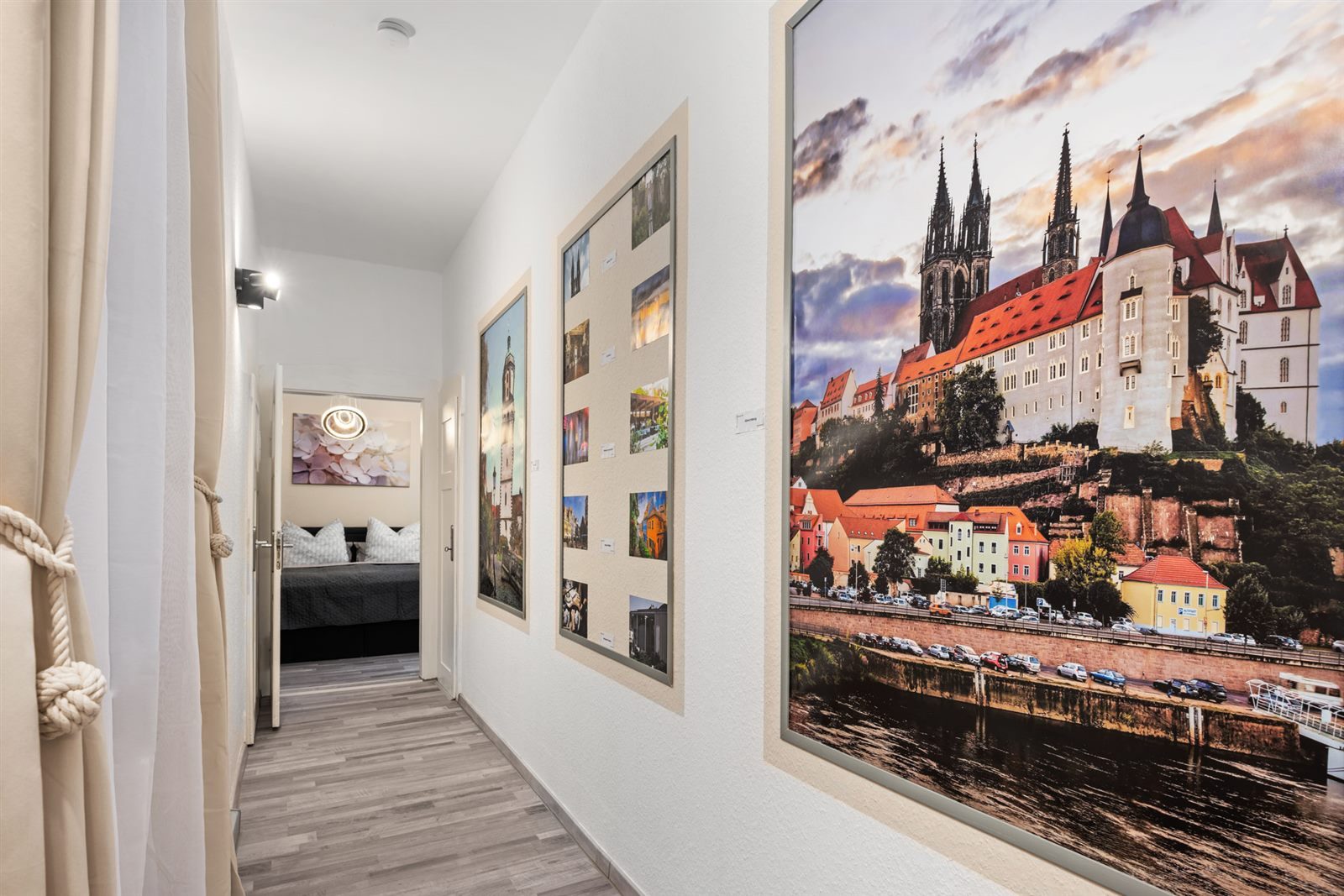 Galerie-Flur mit großformatigem Albrechtsburg-Motiv und Meißen-Fotos – schon beim Ankommen spüren Sie das historische Flair der Porzellanstadt