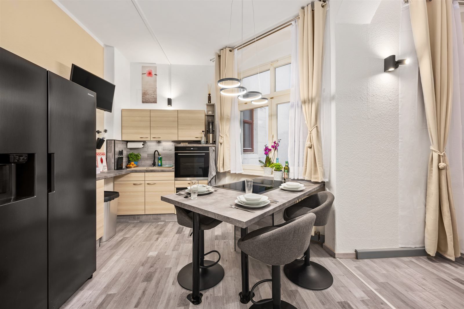 Offener Küchen- und Essbereich mit großem Side-by-Side-Kühlschrank und Barhocker-Theke – viel Raum zum Genießen und gemütlichen Verweilen