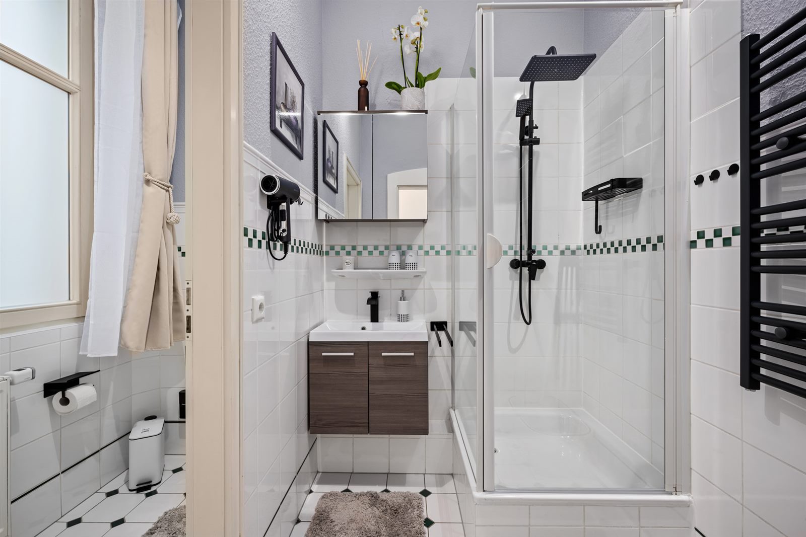Modernes Badezimmer mit ebenerdiger schwarzer Regendusche und Tageslicht – frischen Sie sich wie in einem kleinen Wellness-Refugium auf