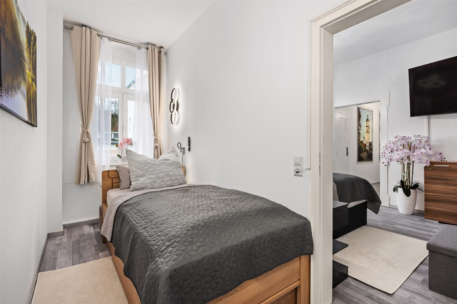 Heller zweiter Schlafplatz mit Einzelbett und Durchblick ins Wohnzimmer – ideal für eine dritte Person oder das mitreisende Kind