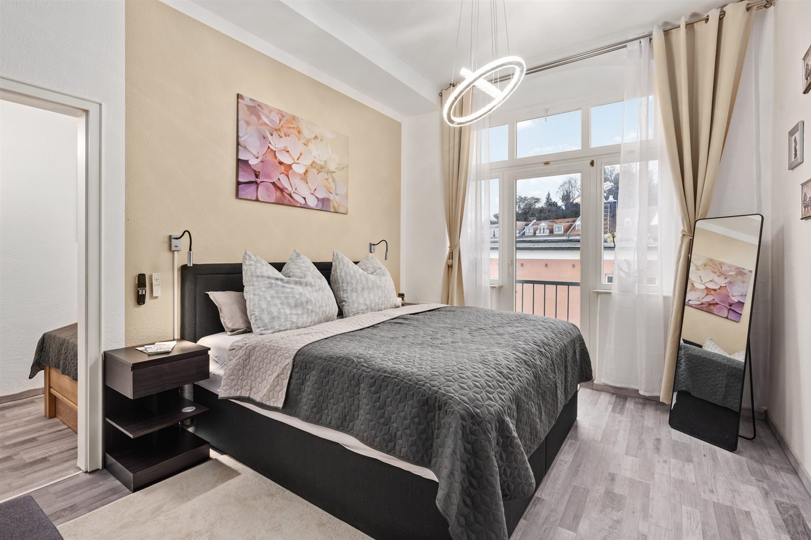 Elegantes Schlafzimmer mit bodentiefem Fenster und Stadtblick – viel Tageslicht und ein Hauch von Urlaubsluxus