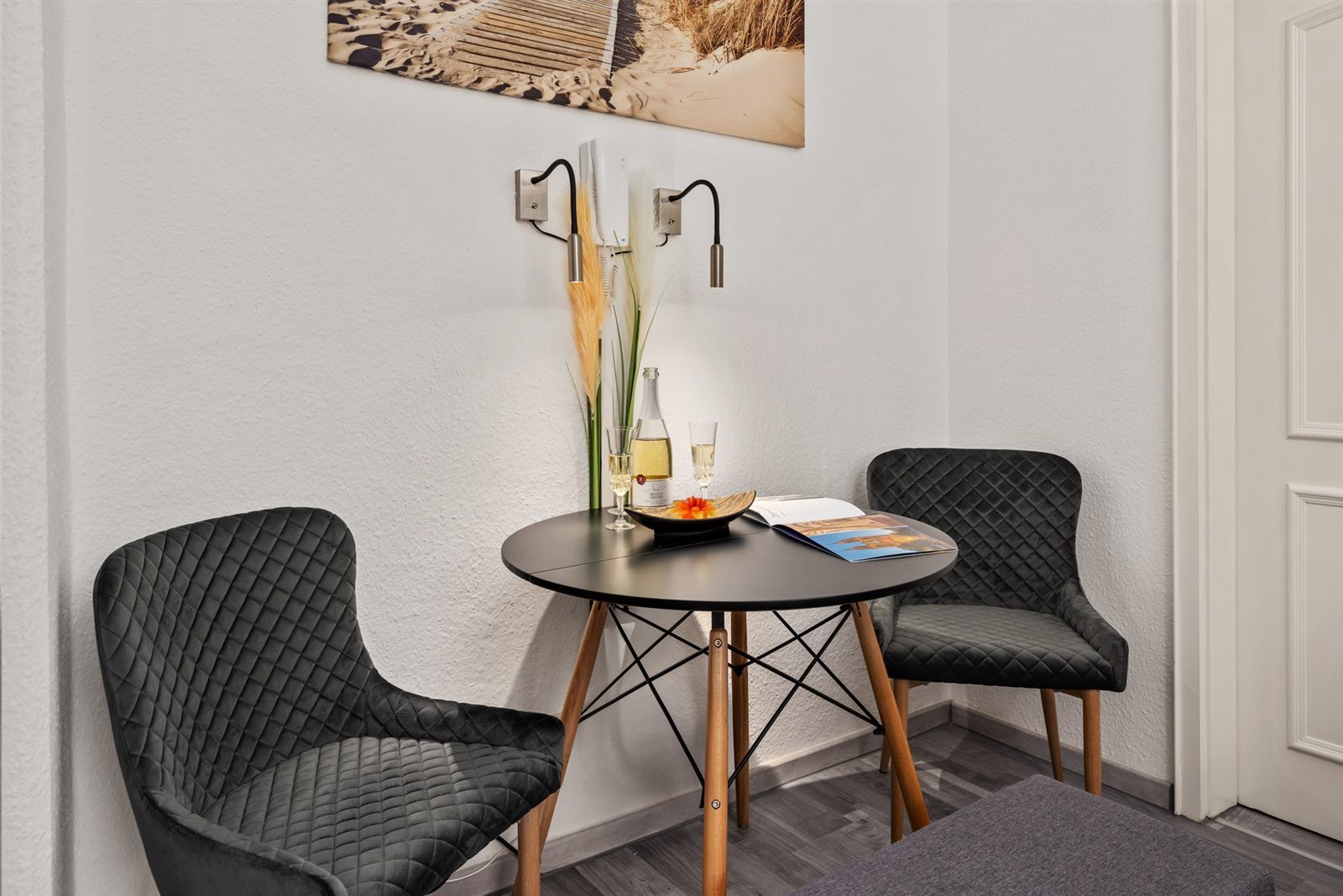 Gemütliche Sitzecke mit zwei Samtsesseln und kleinem Tisch – der perfekte Platz zum Ankommen mit einem Glas Sekt