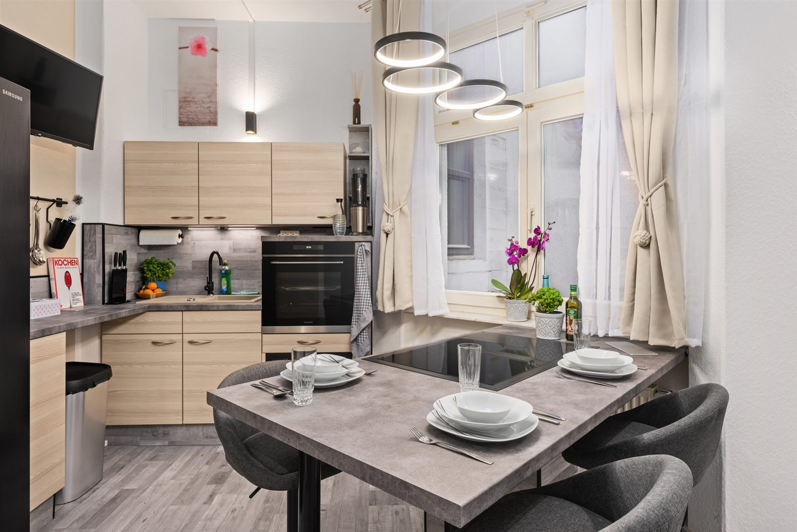 Heller Essplatz mit Induktionskochfeld und Designer-Pendelleuchte – gemeinsam kochen und gemütlich zu zweit speisen