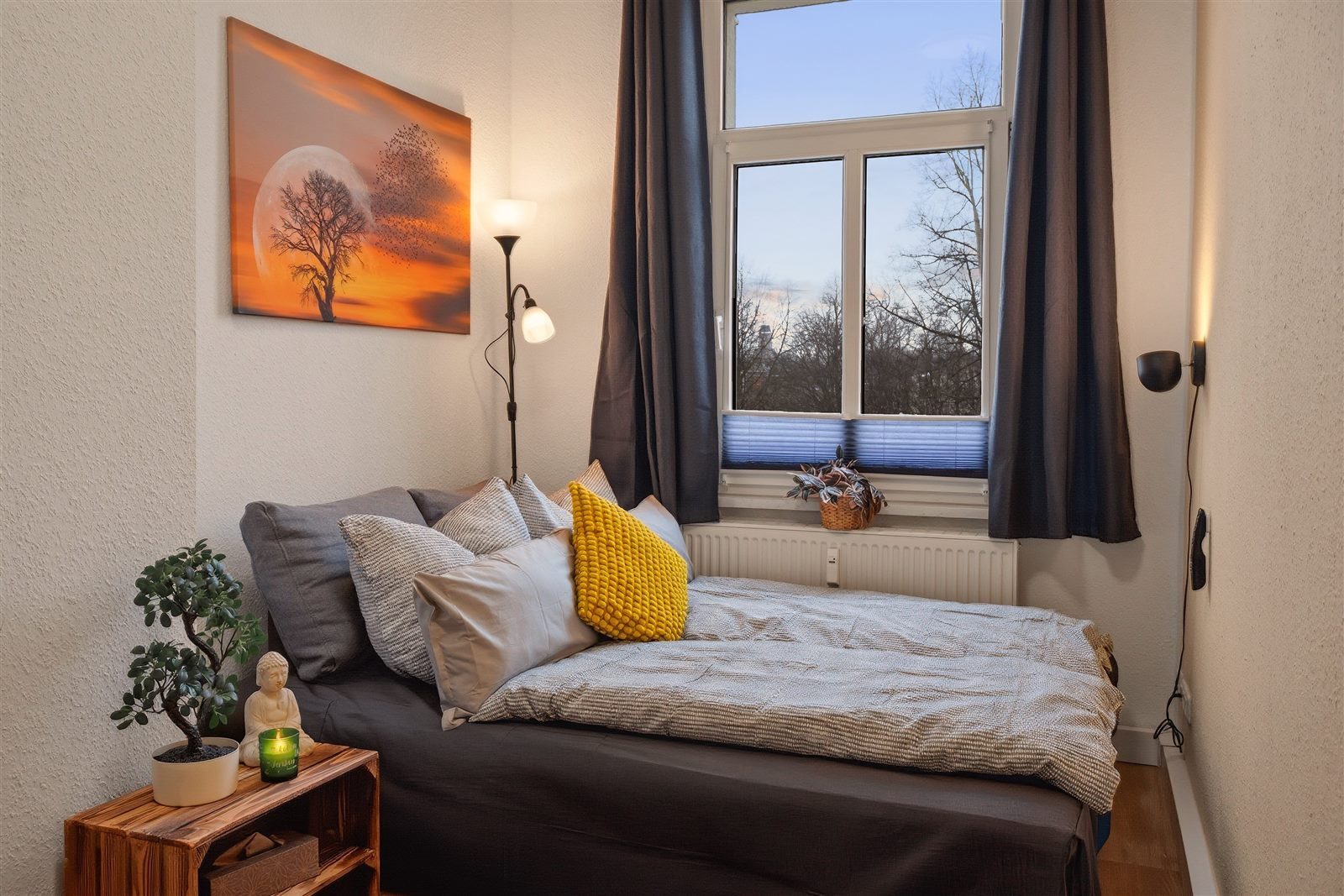 Behagliches Schlafzimmer mit stimmungsvoller Beleuchtung und Stadtblick – erholsame Nächte mitten in Chemnitz