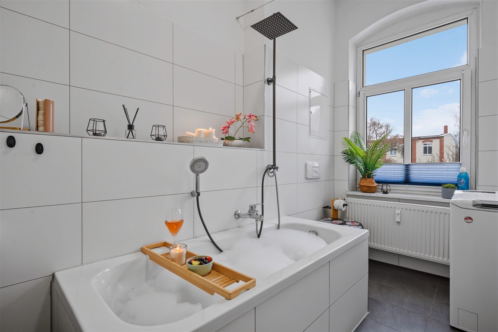 Einladende Badewanne mit Schaumbad und Roséwein – kleine Wellness-Auszeit am Abend