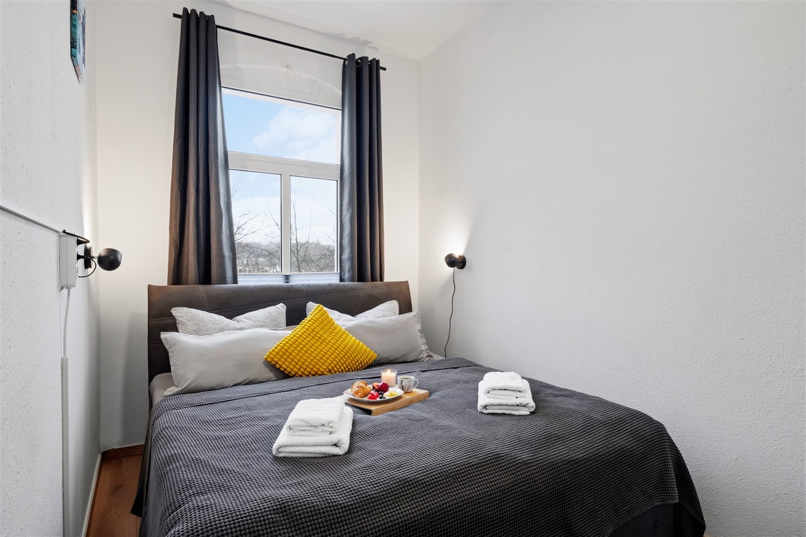 Kuscheliges Schlafzimmer mit hochwertiger Bettwäsche und Stadtblick – erholsamer Schlaf nach einem ereignisreichen Tag